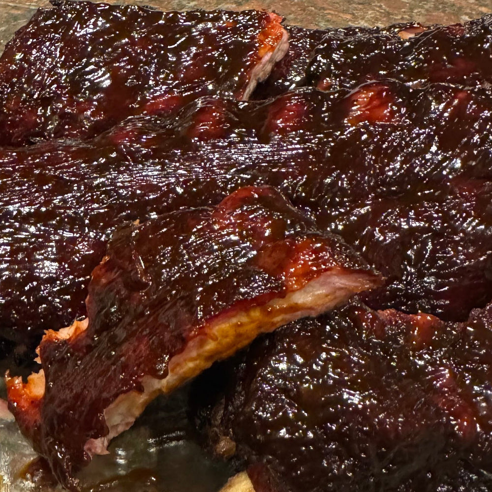 Barbecue ribs with a bottle of sauce on counter