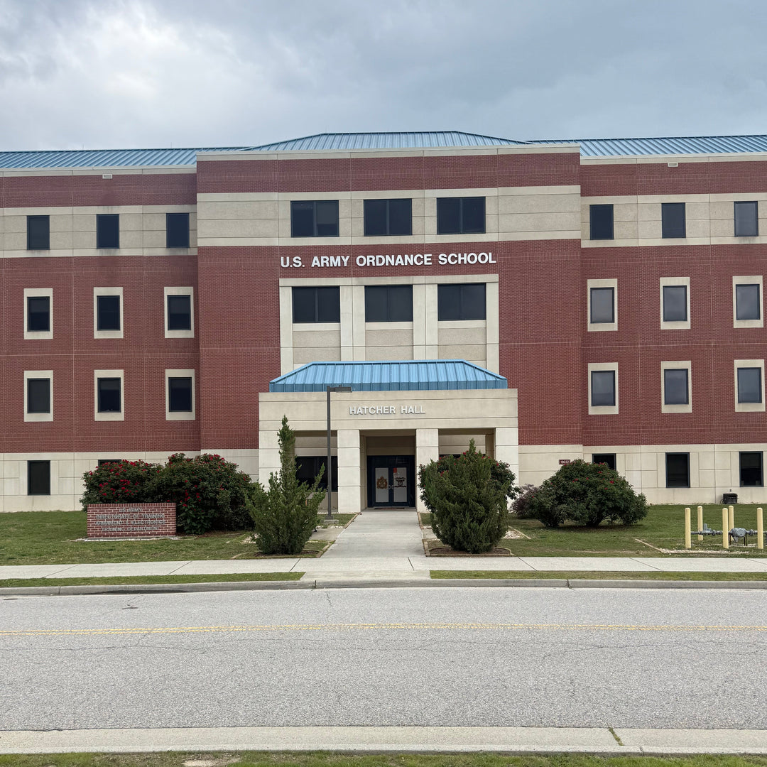 Aerial view of a building labeled 'U.S. Army Ordnance School' with a road and grass area.